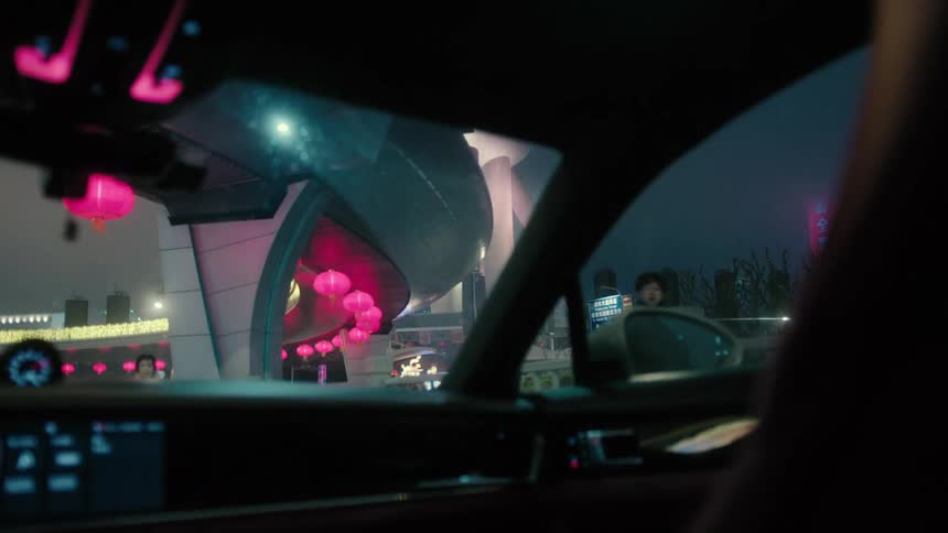 Interior view of a vehicle traveling through a modern metropolis at night