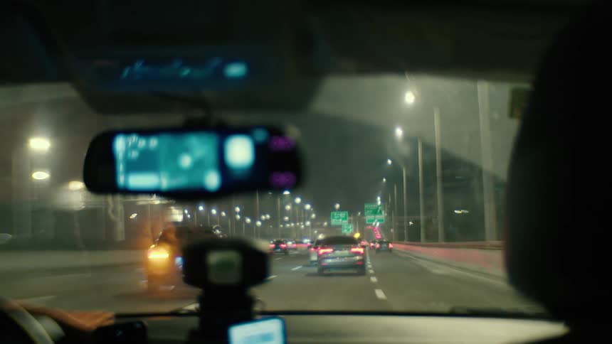 Nighttime inside vehicle perspective on a city street