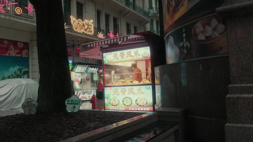 A worker prepares food in a small street restaurant on a city street