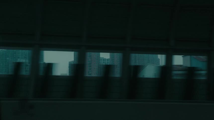 View from the window of a moving vehicle of buildings in a metropolis from an overpass