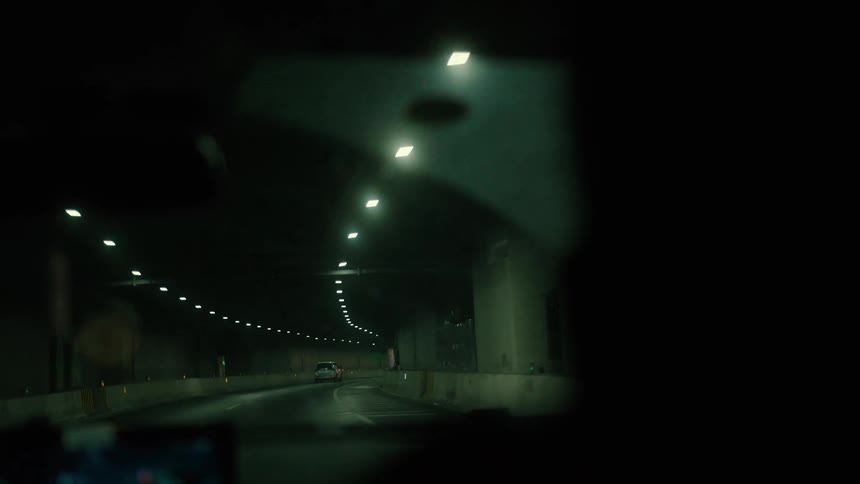 Interior of a vehicle going through a tunnel in the city at night