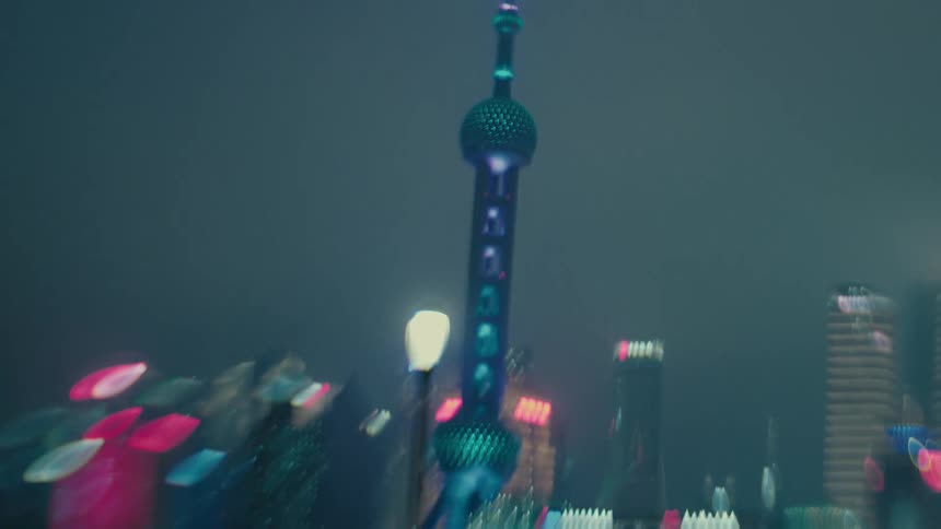 Street with pedestrians on the edge of a river canal in a shanghai metropolis at night