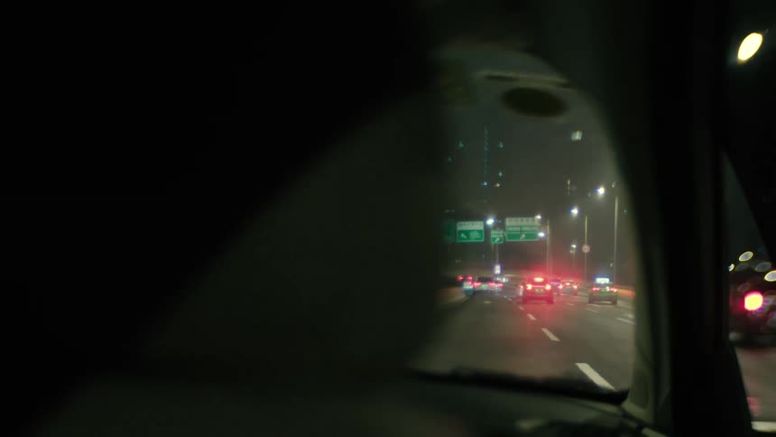 Cars drive down a highway in a city