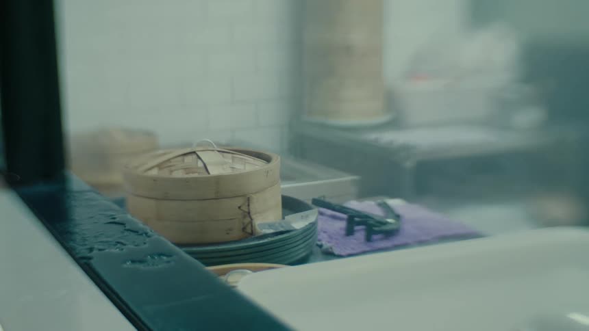 A basket of chinese food in a large steamy kitchen