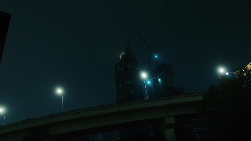 Upward view of a viaduct and skyscrapers in a metropolis at night
