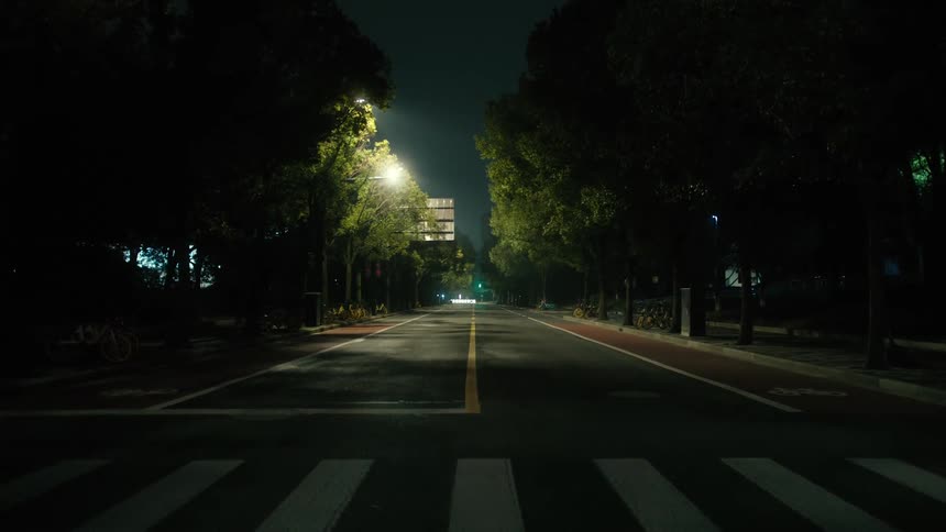 A bright light shines over an empty road in a city