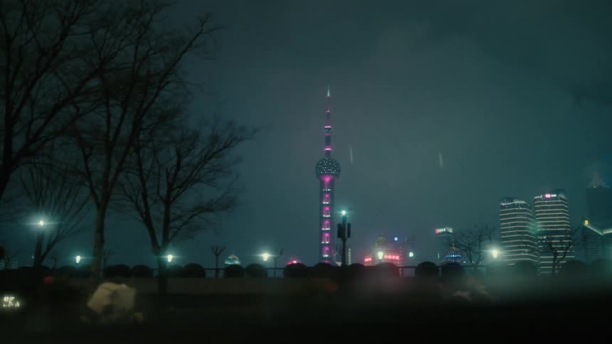 View from the window of a moving car to a metropolis with a skyscraper and residential buildings in a metropolis at night