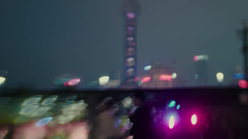 Silhouette of people walking and in the background buildings and skyscrapers in a city illuminated at night