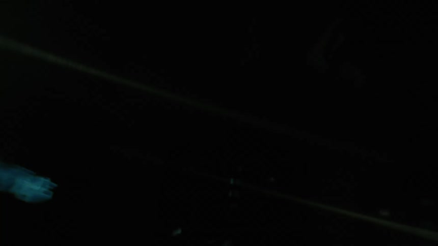 Upward view from the window of a moving vehicle of skyscrapers in an illuminated metropolis at night