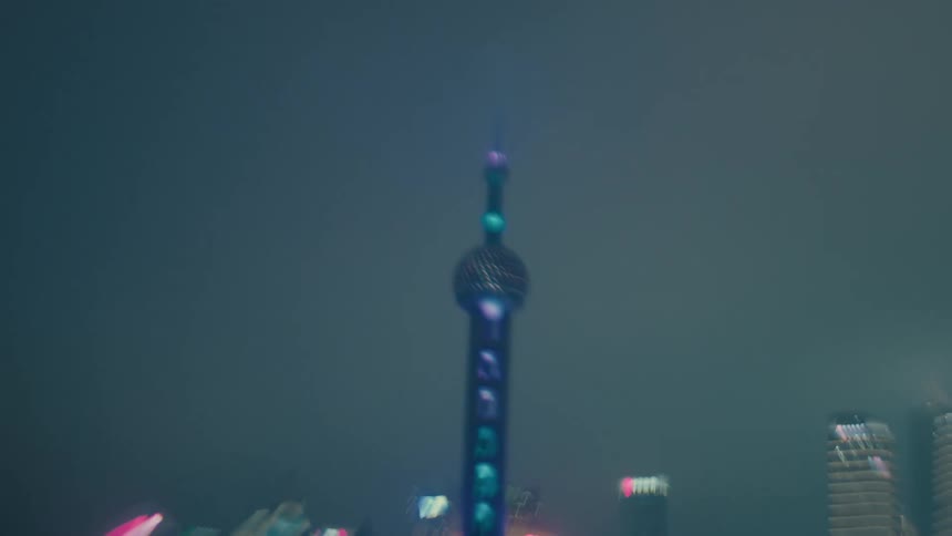View of shanghais pearl of the orient tower illuminated at night in a seaside metropolis