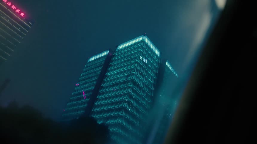 Skyscrapers in the city at night seen from a moving vehicle