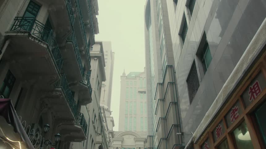 People walking on a wet street in a metropolis with large buildings