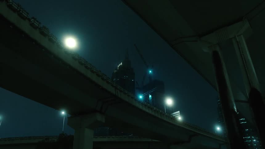 Nighttime city view with buildings and an overpass