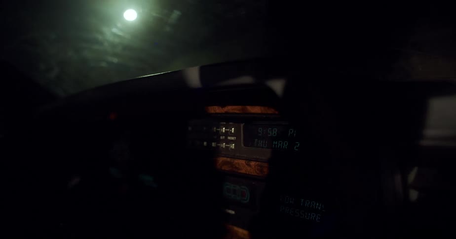 Close up of the dashboard of a vintage car driving at night