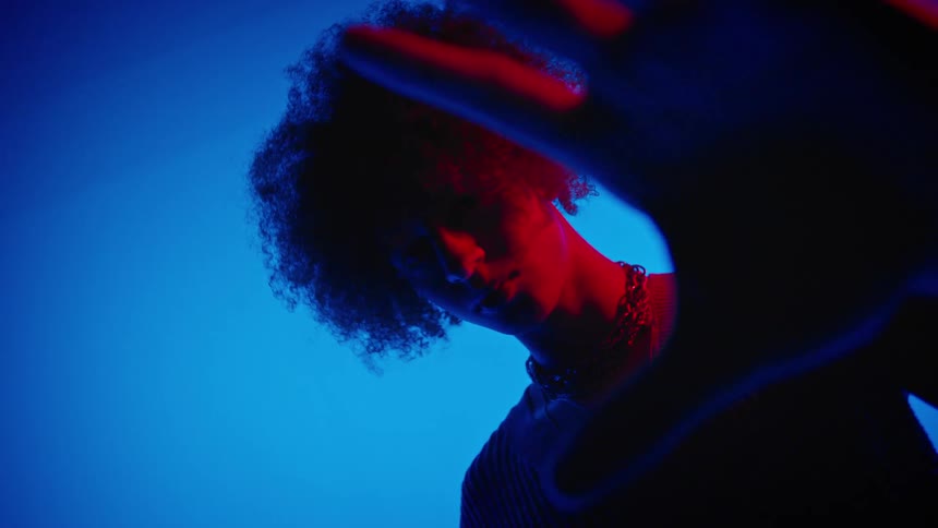Portrait of a male model showing his palm while standing in a studiolit environment