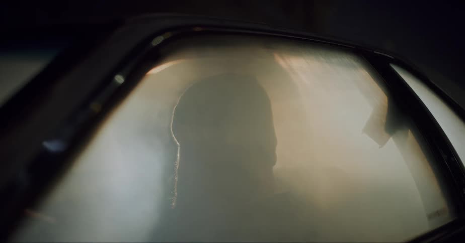 Portrait of a man inside a car that begins to overflow with smoke inside