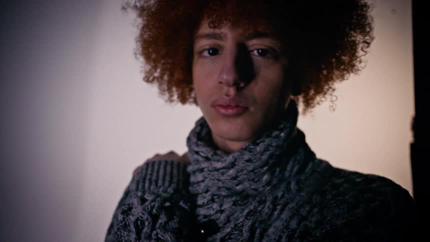 Portrait of a young man wearing a wool sweater modeling inside a studio