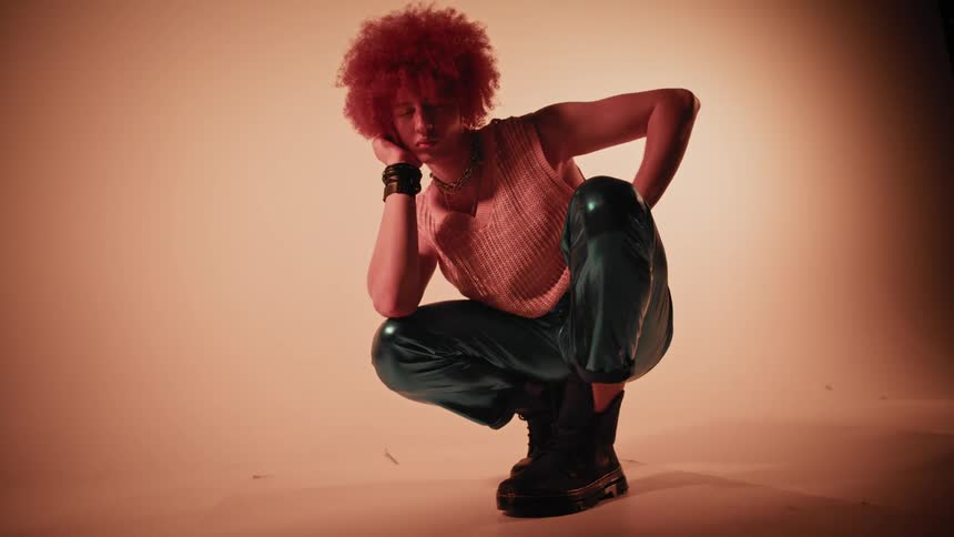 A young male with red hair strikes multiple poses as he models