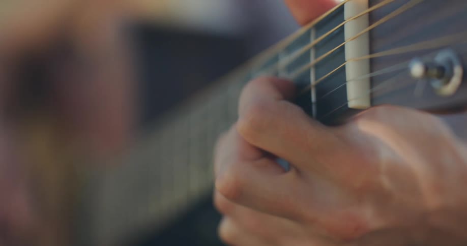 Closeup of a persons hands playing the guitar