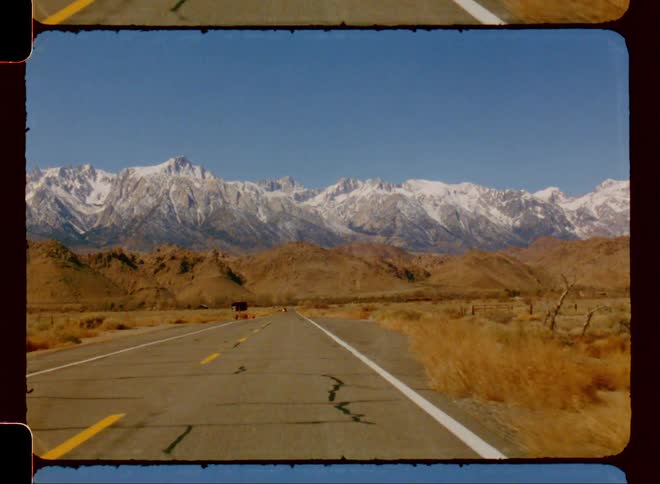 Driving on a road through the desert next to the mountains