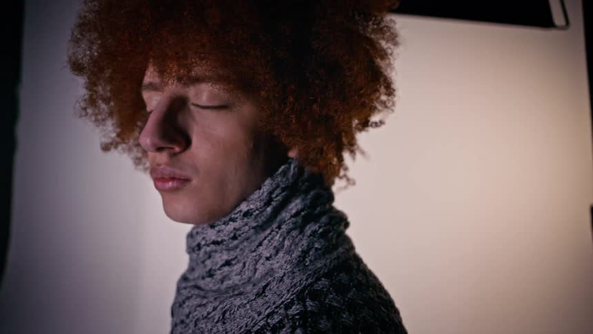 Close up of a model with curly hair looking at the camera