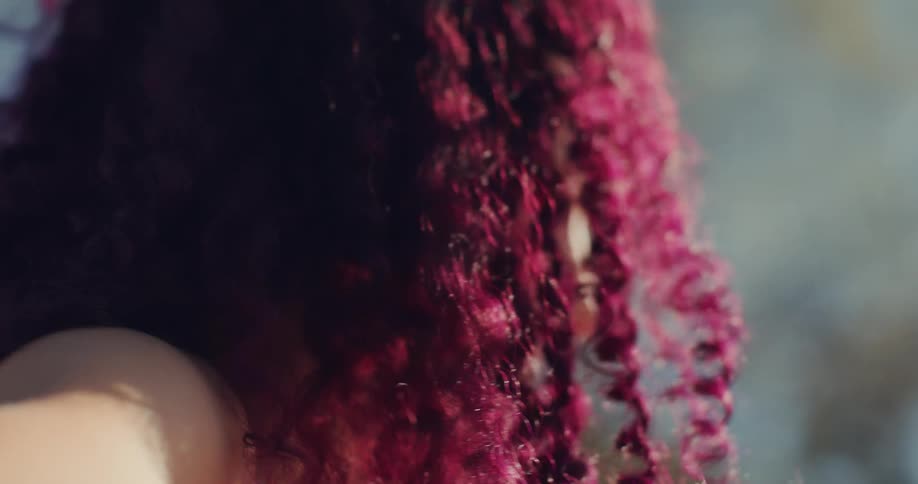 A woman with pink curly hair