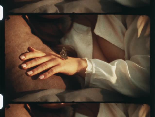 A womans hand with a butterfly and the reflection of sunlight