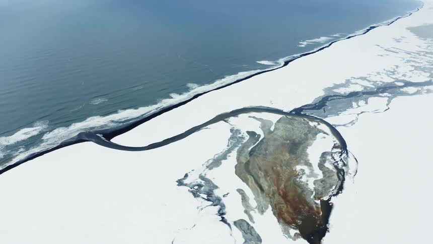 The shore is covered with snow and ice