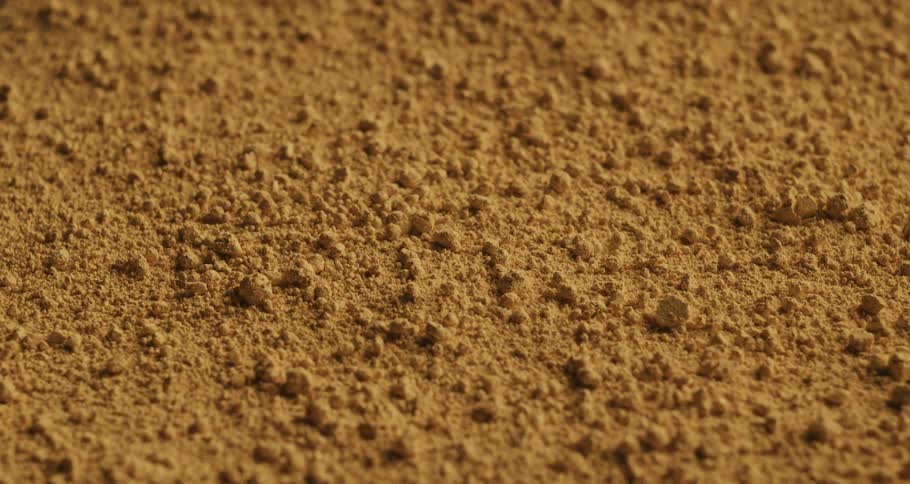 Closeup on the ground with bouncing sand in slow motion