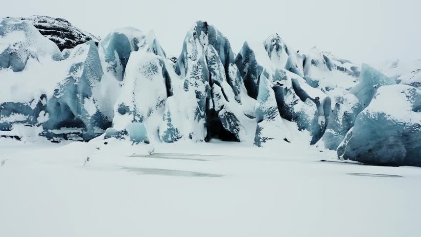 Scenery of sharp glacier covered in snow on a cloudy day