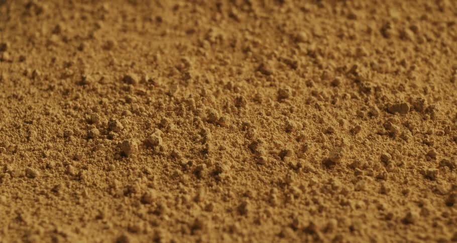 Extreme closeup on a golden powder bouncing in slow motion