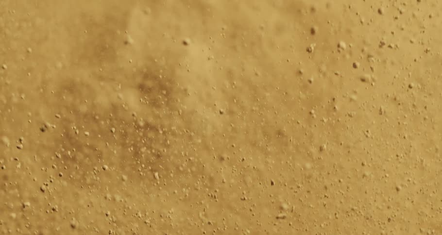 Extreme closeup on an exploding sand texture in slow motion