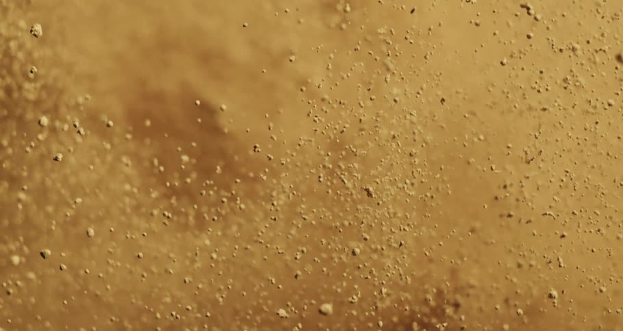 A sandy substance explodes and flies through the air before falling back down