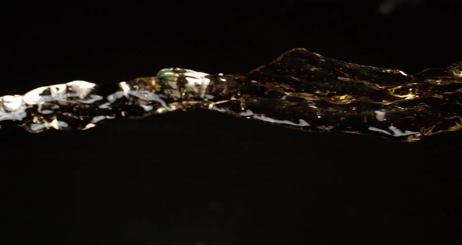 A splash of yellow liquid flies over a dark background