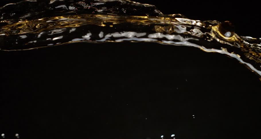 Golden beverage splashed through the dark sparkles