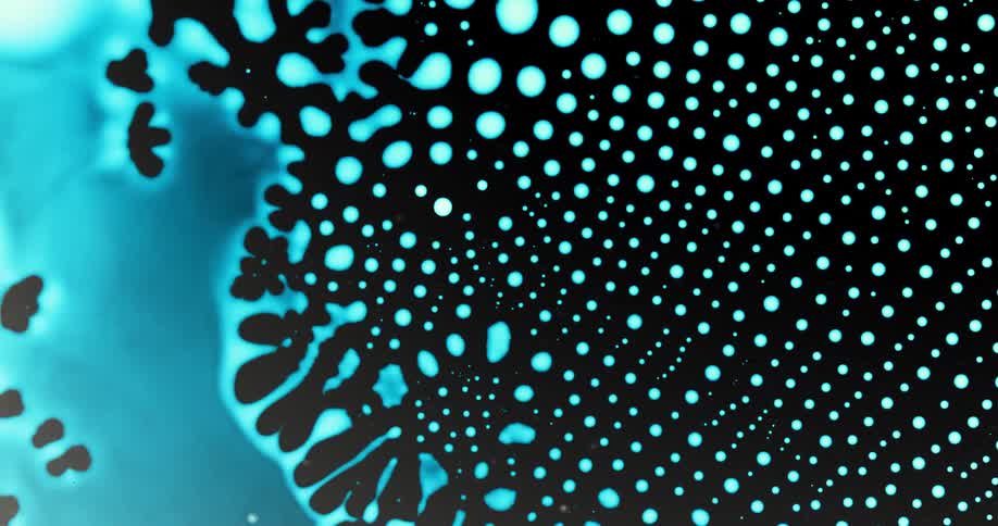 Extreme closeup of vibrant blue liquid collapsing into patterns of small abstract droplets