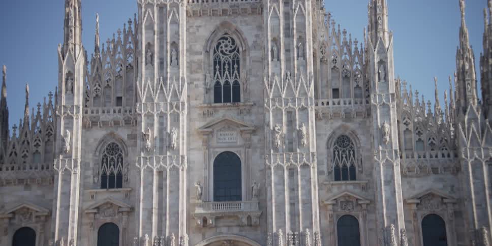 Birds fly around the Cathedral Duomo di Milano in Milan, Italy