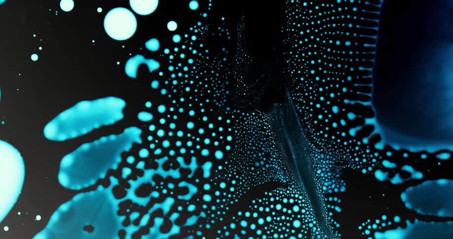 Extreme closeup of a vibrant blue liquid coagulating in slow motion