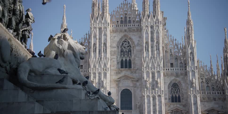 Pigeons over the statues in front of the Cathedral Duomo di Milano in Milan, Italy