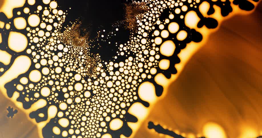 Bubbles forming expanding and popping in an abstract of orange yellow black and white