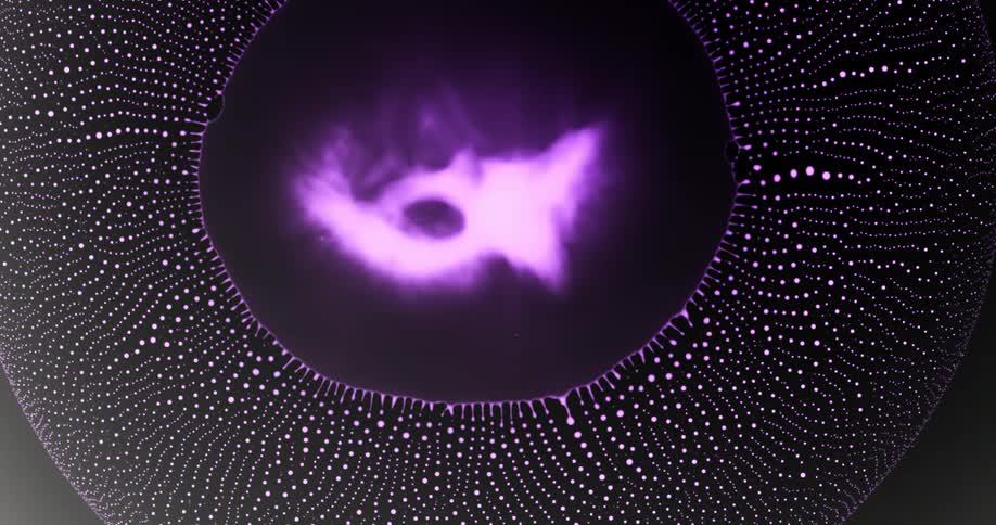 A magenta cloud explodes and a ring of pink orbs emerge and spread across the darkness