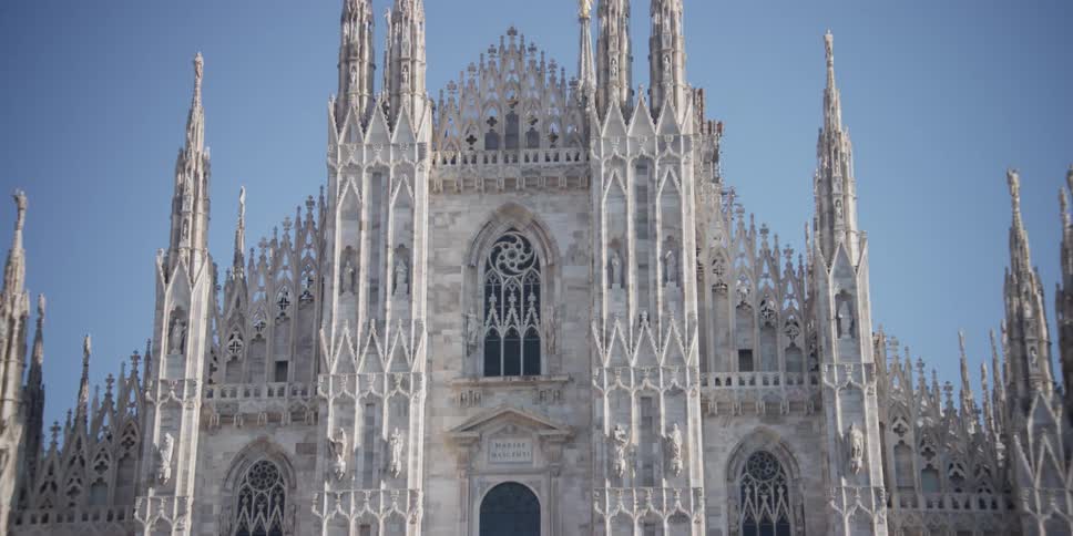 Various birds fly by the historical Cathedral Duomo di Milano in Milan, Italy