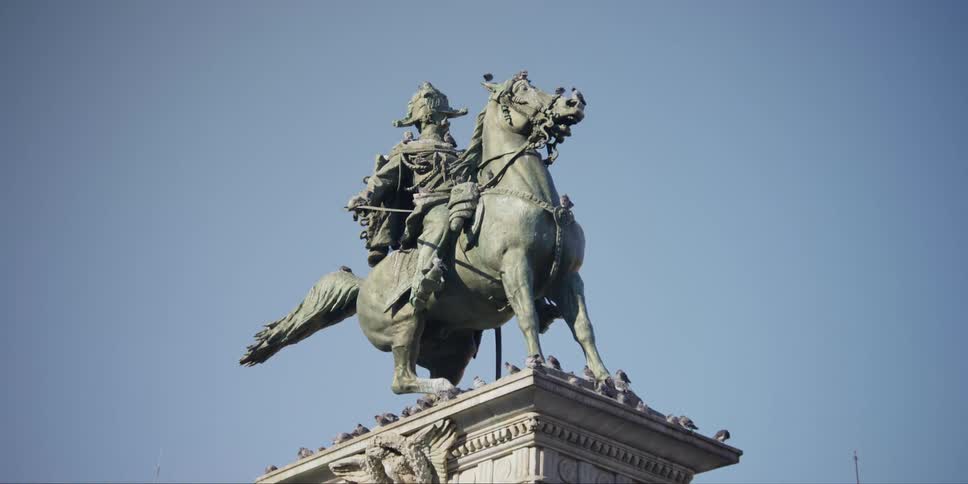 Pigeons cover statue of King Vittorio Emanuele II in Duomo Square, Milan, Italy