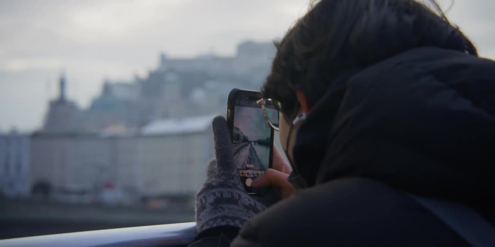 Person takes pictures of Salzburg, Austria from across the River Salzach