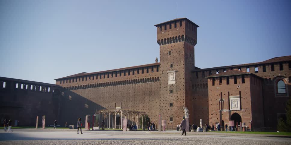 People walking across the square in front of Sforza Castle, Milan, Italy