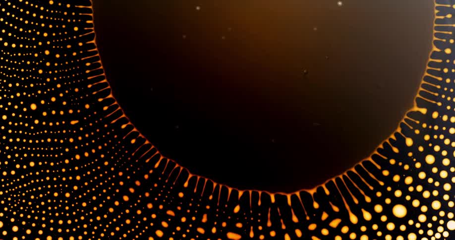 A blob of bright yellow ink expands and contracts leaving a trail of droplets
