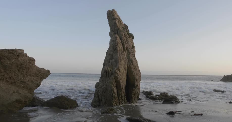 A rocky shore with the sky and the ocean in the background