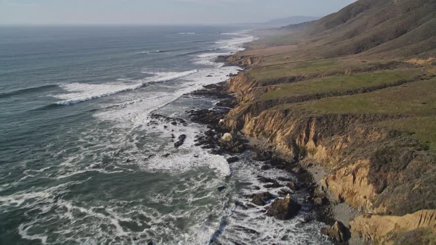 Aerial scenery of the sea at the edge of the mountain coast during the day