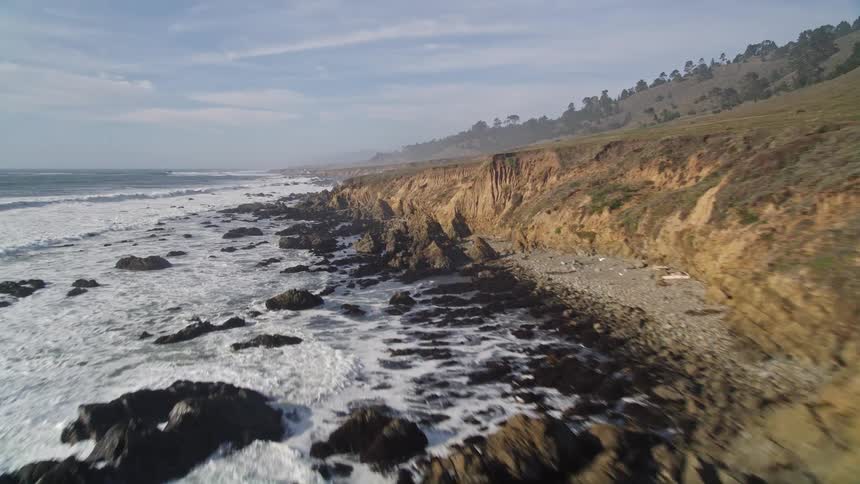 Aerial of a rocky ocean coast on a mostly cloudy day