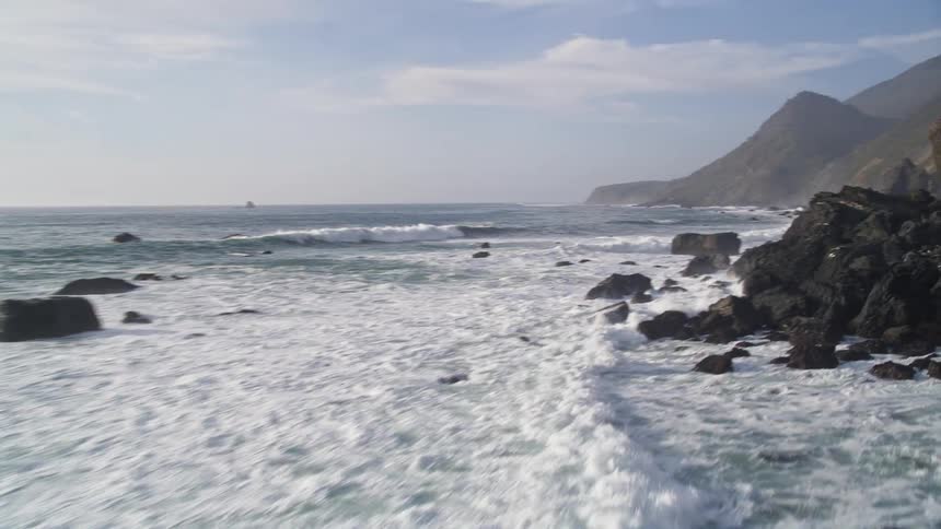 Natural scenery of the sea and mountain coast during a blue sky day with clouds